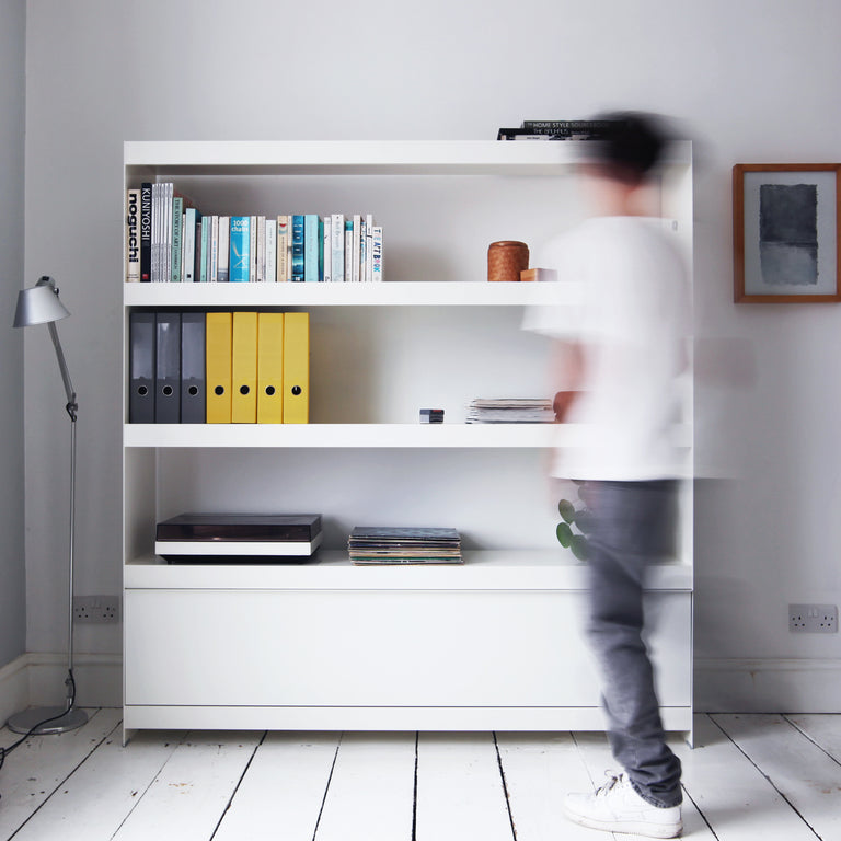 Large white modular shelving unit with door